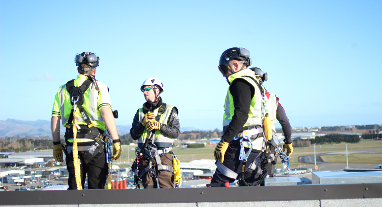 Four PBI Staff standing on a roof overlooking Christchurch with a full height safety solution. 